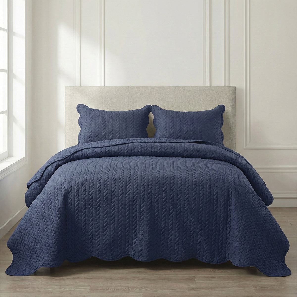 Navy blue quilted cotton bedding set with two pillow shams in a bright modern bedroom